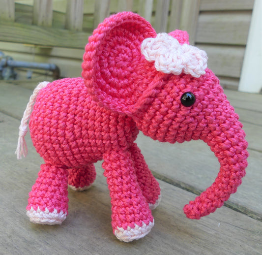 Pink crocheted elephant with a light pink flower on its head