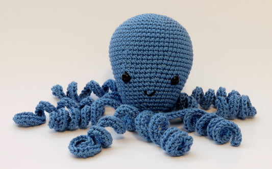 Light blue crocheted octopus with curly tentacles